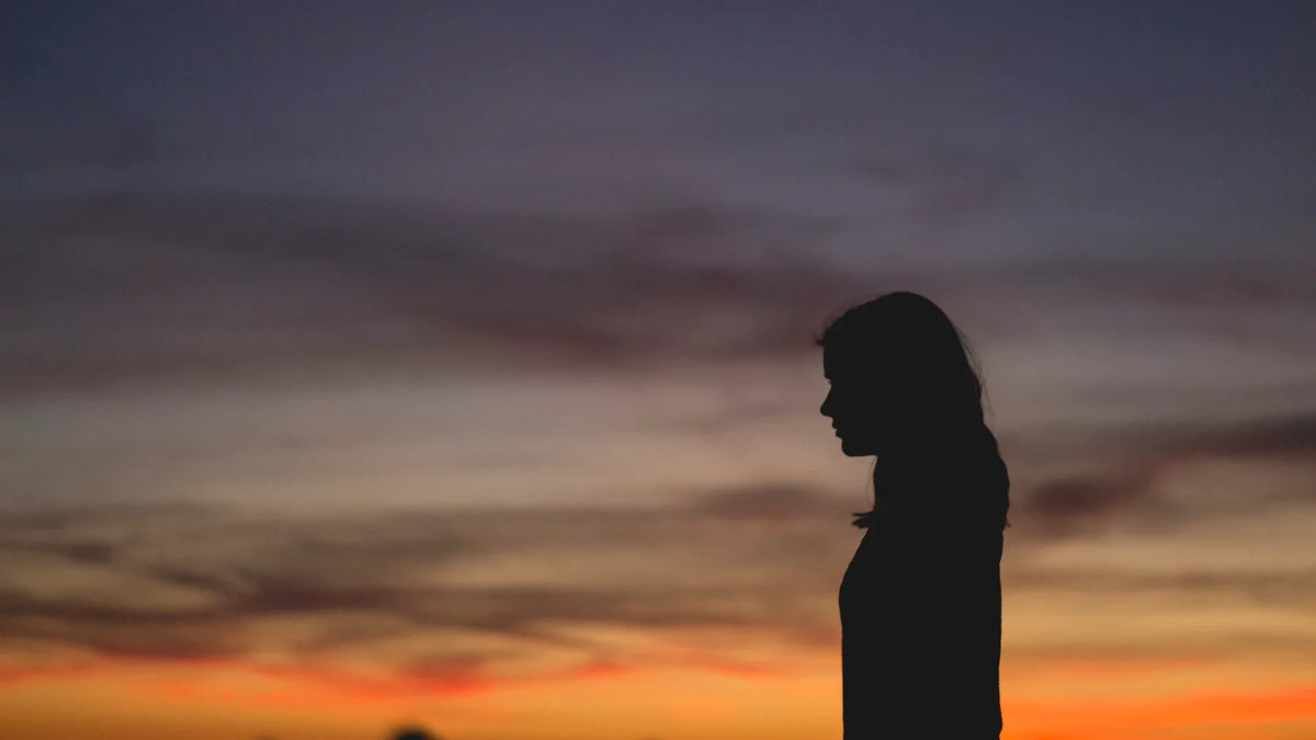 A person silhouetted against the sky at sunset.