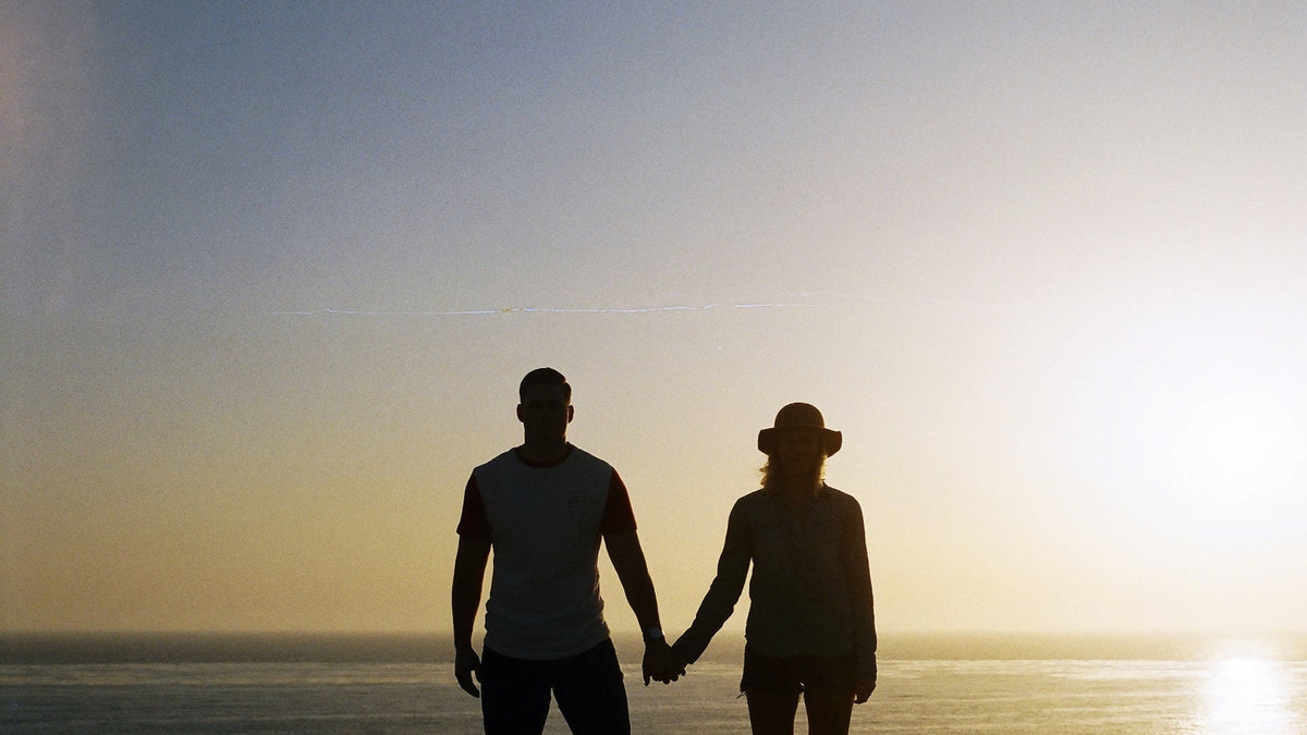 Two adults holding hands in silhouette.