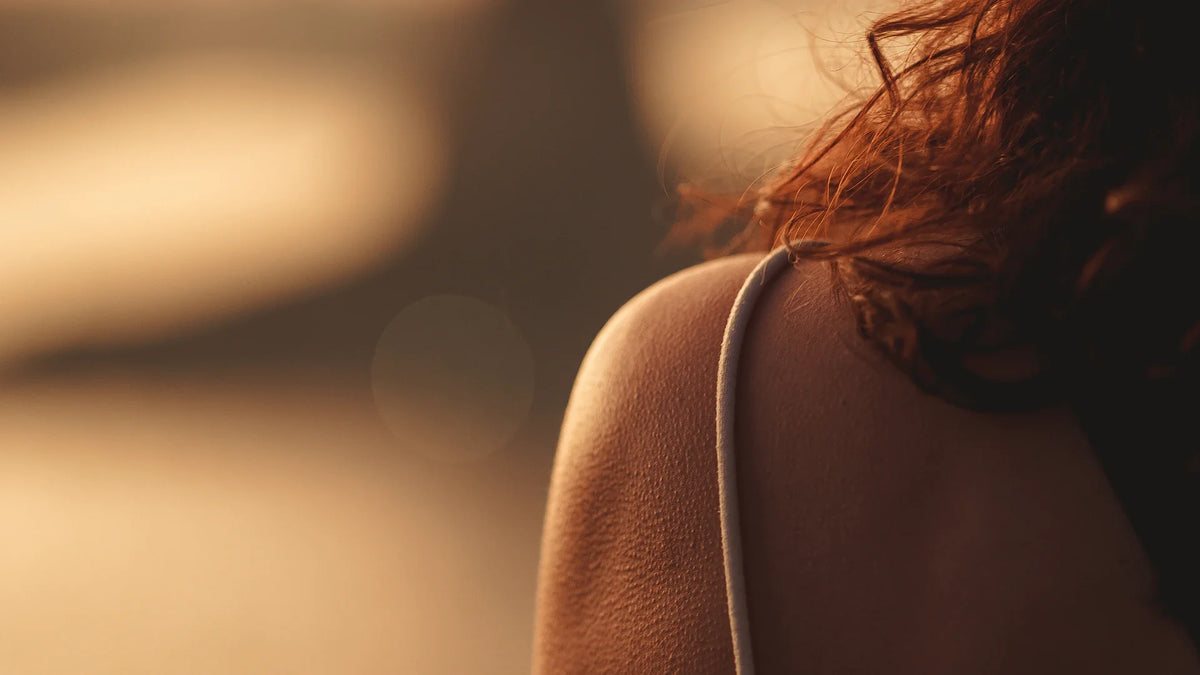 An adult woman viewed from behind in natural light.