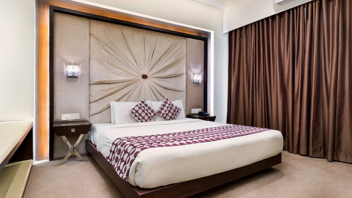 A made bed with white bedding in a softly lit room.