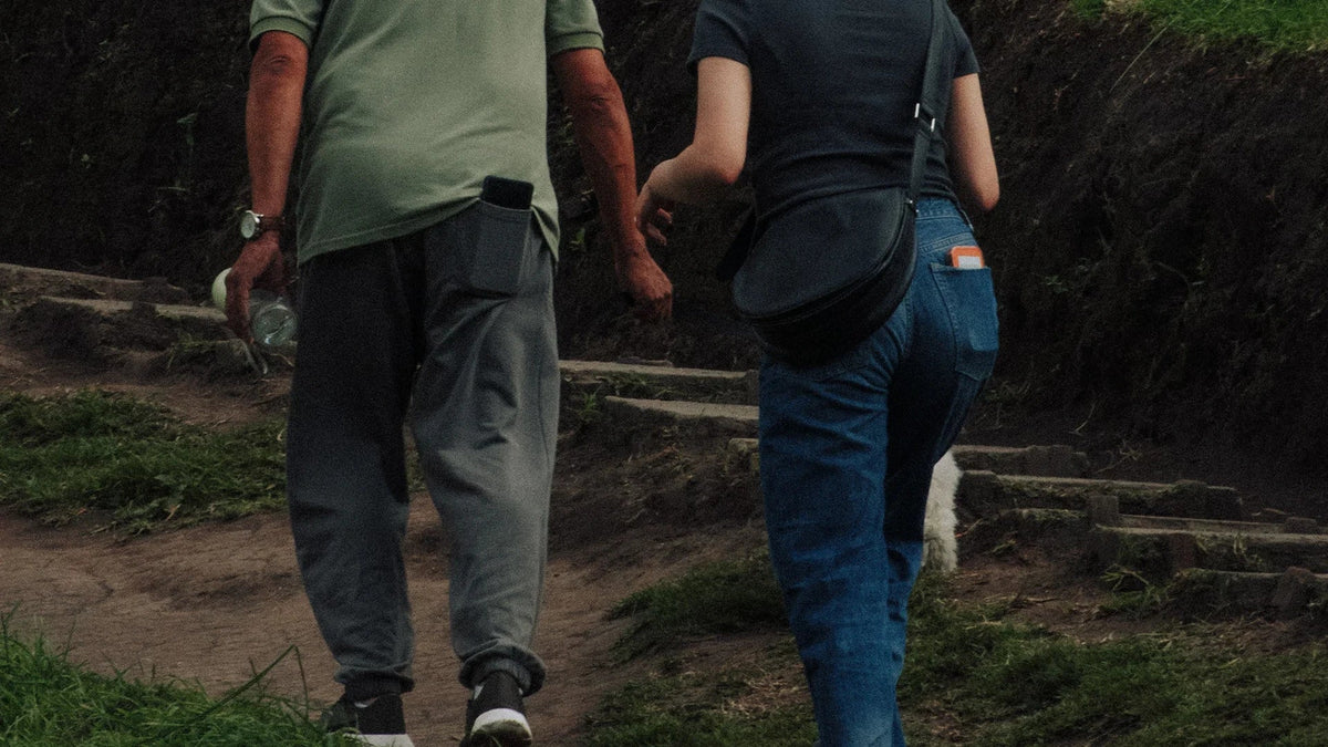 Adult companions viewed from behind while walking outdoors.