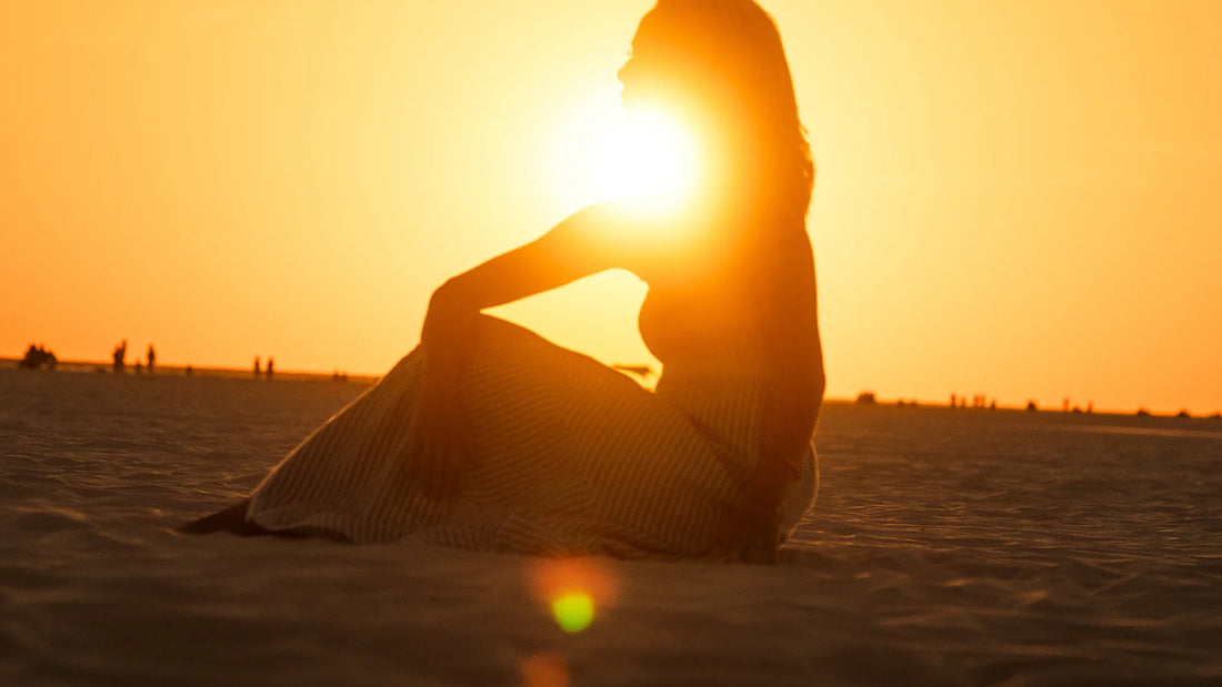 An adult woman silhouetted against the evening sky.