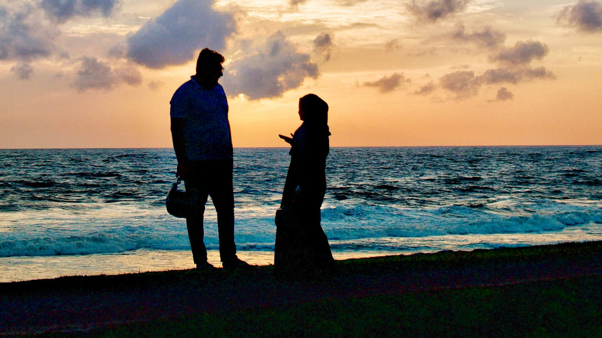 Adult companions silhouetted together outdoors.
