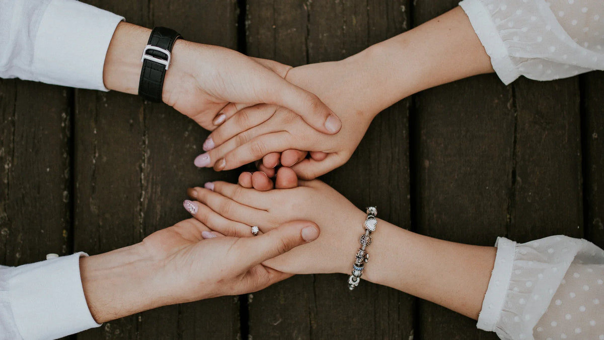 Close view of adult companions holding hands.