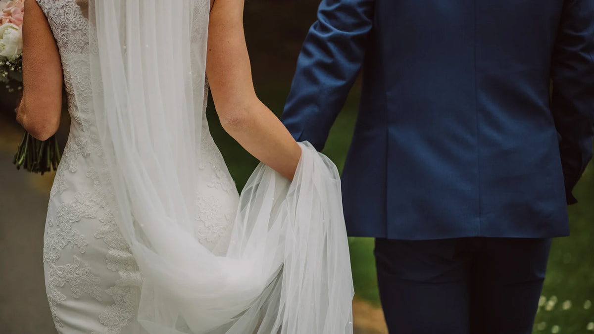Adult companions viewed from behind while walking outdoors.