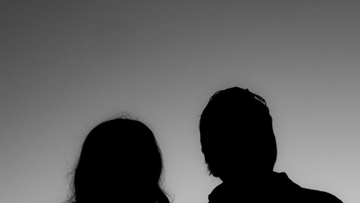 Adult companions silhouetted outdoors.