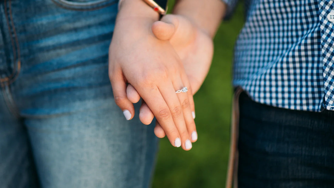 Two hands are held together outdoors.