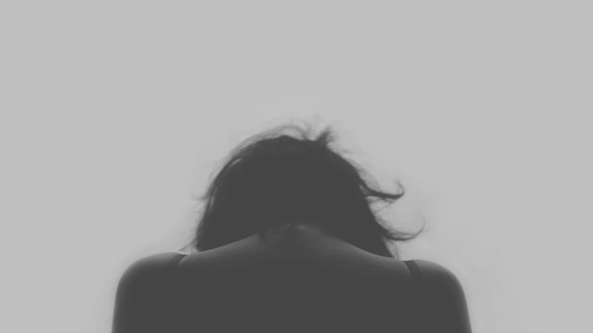 An adult woman seen from behind.