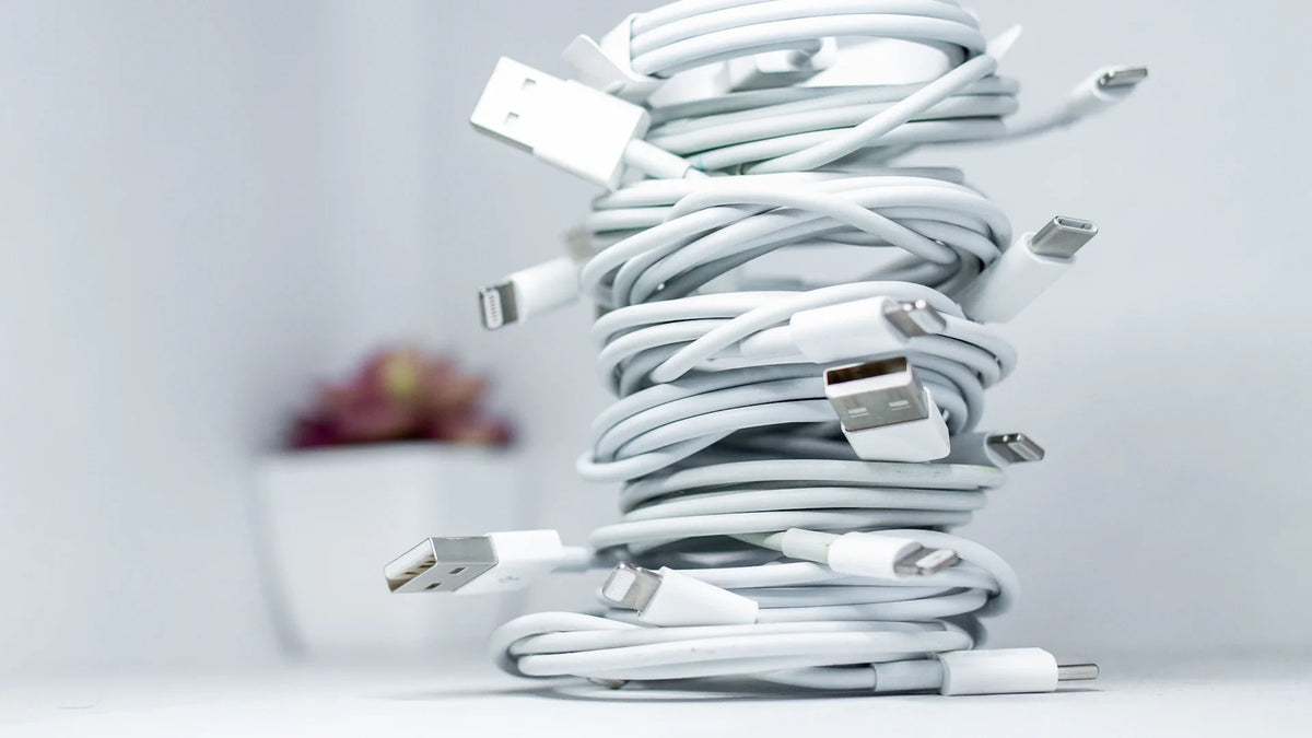 Coiled white charging cables stacked on a table.