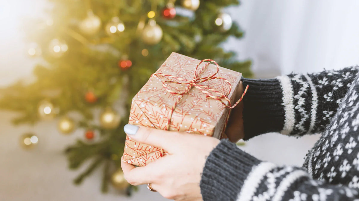 A person holding a wrapped gift box.