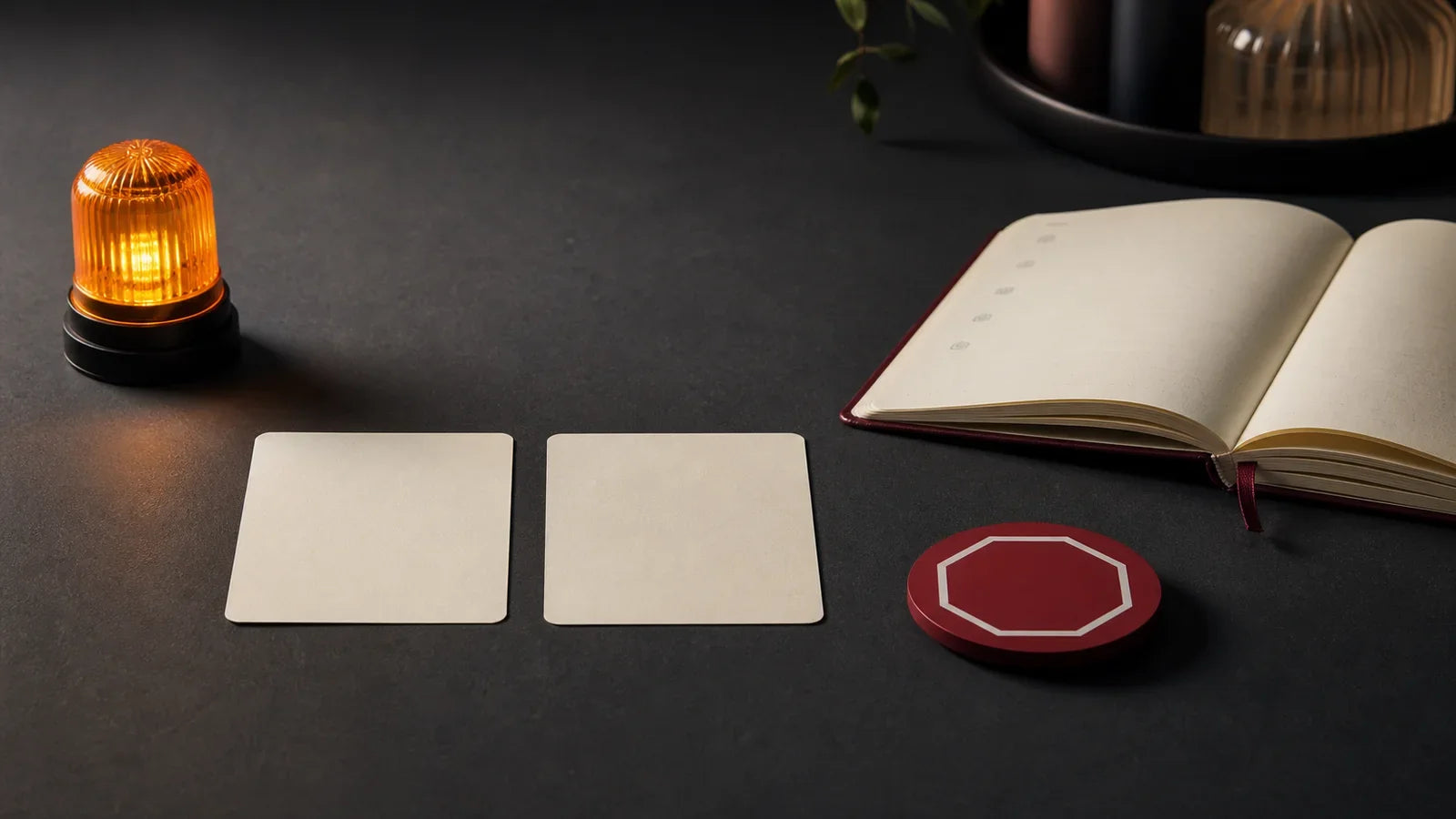 Amber caution light, blank agreement cards, notebook and red stop token representing the RACK framework