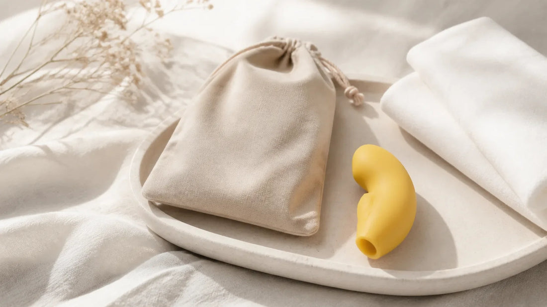 Unbranded yellow external wellness device on a pale stone tray beside a beige pouch and folded white cloth.