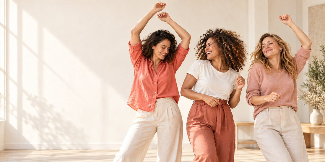 Three women sharing a joyful moment in a sunlit room